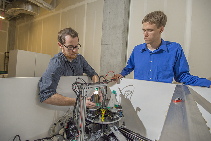 Two CEI Graduate Fellows examine a scientific instrument.