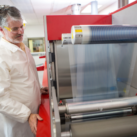 Devin Mackenzie and the roll-to-roll printer at the Testbeds