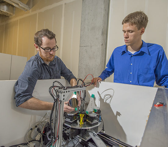 Two CEI Graduate Fellows examine a scientific instrument.