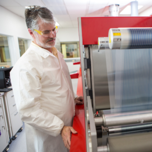 Devin Mackenzie and the roll-to-roll printer at the Testbeds