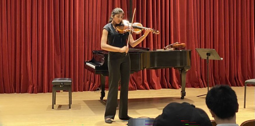 Meghna Shankar playing viola, alone on stage