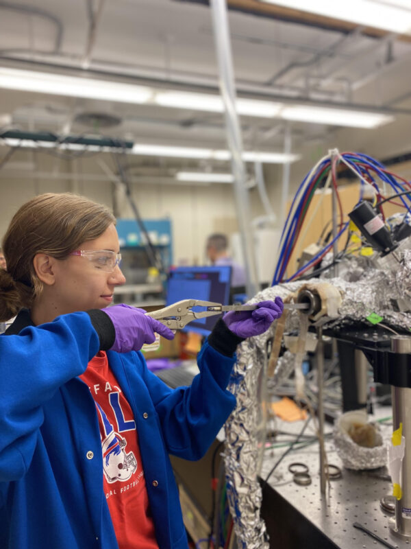 Joelle Scott loading a sample into a lab reactor